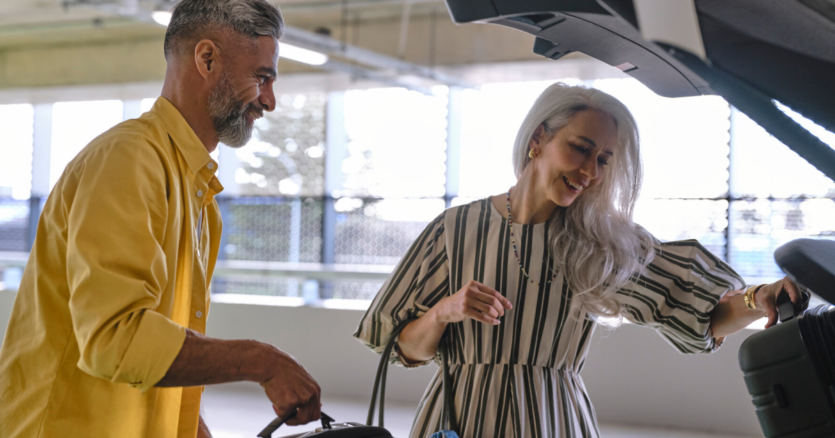 two people take suitcases out of a car at Auckland Airport's Transport Hub car park